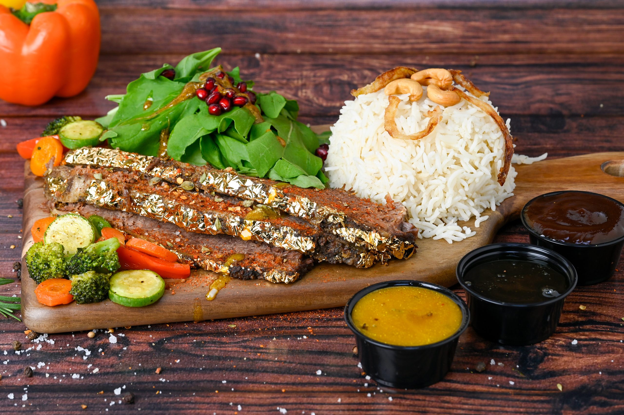 Slow-cooked brisket platter with rice, fresh salad, and dipping sauce – 24K Meats specialty